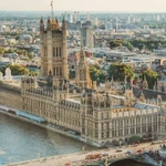Aerial view of the UK Houses of Parliament and Westminster Bridge on a sunny day, as MPs debate gambling advertising reform.