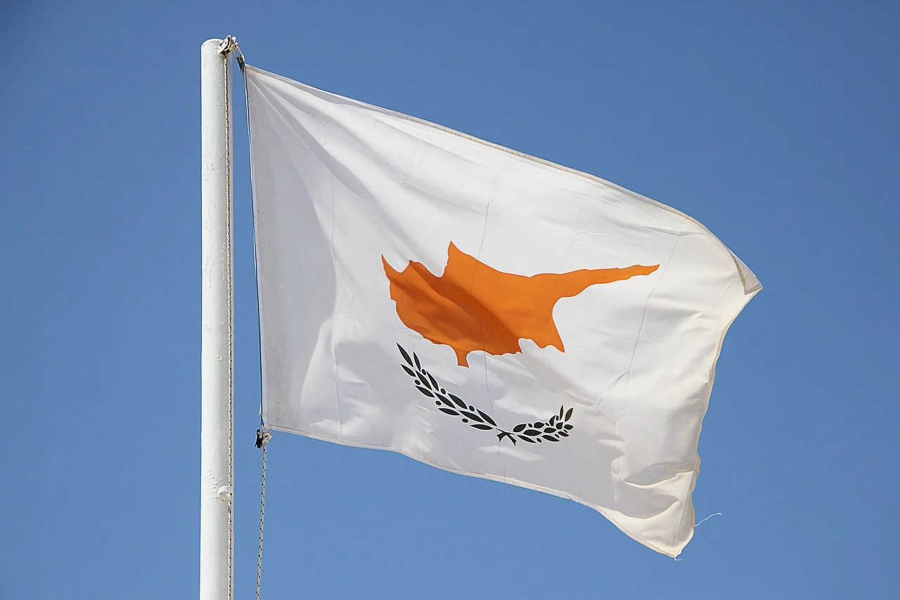 Cyprus flag waving against a blue sky, symbolising GMI recipients gambling regulation