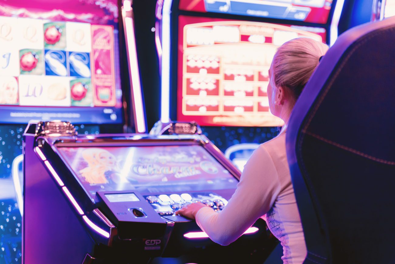 Автомат компьютер. Happy woman gambling at Casino playing Slot Machine. Safe gambling. Responsible gambling.